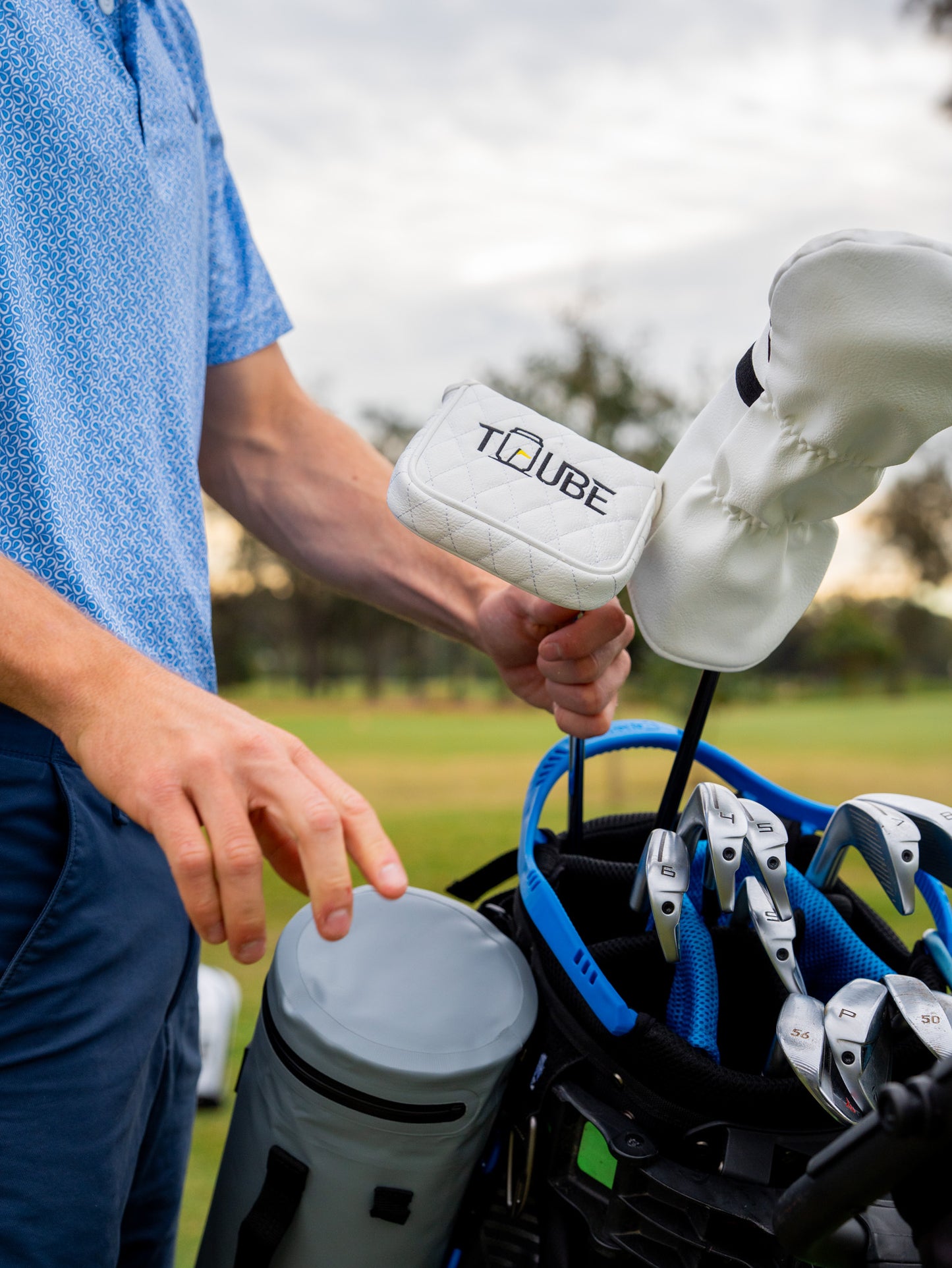 Tuube Putter Head Cover - Golfer putting putter cover onto putter.