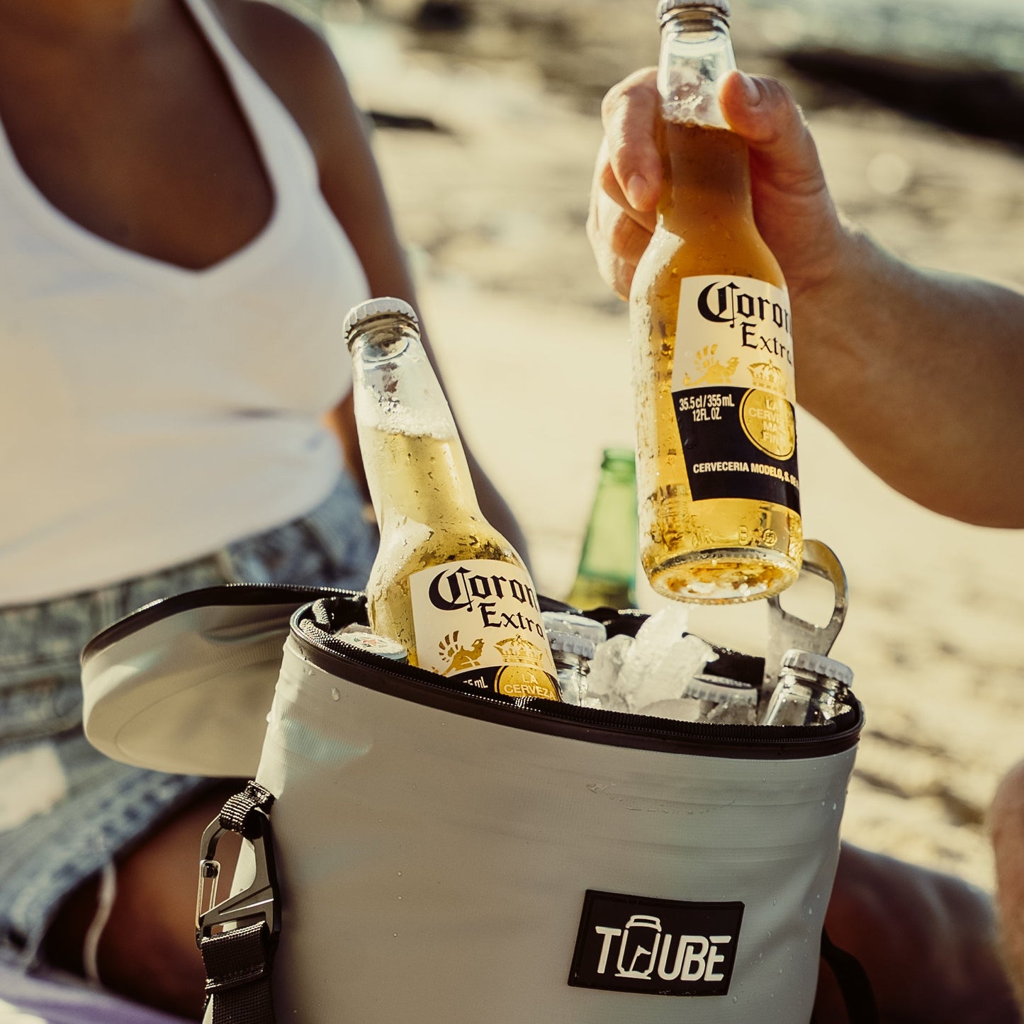 Tuube Weekender 8L grey cooler bag packed with drinks, showing 8L capacity and heat-welded leakproof body in a beach setting
