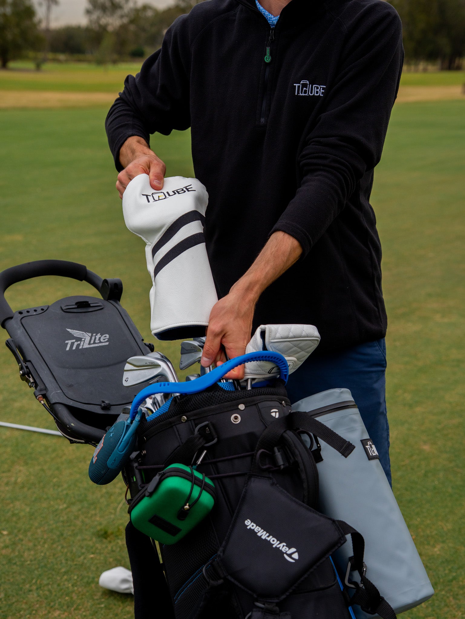 Tuube Head Cover - Golfer pulling head cover off clubs. 