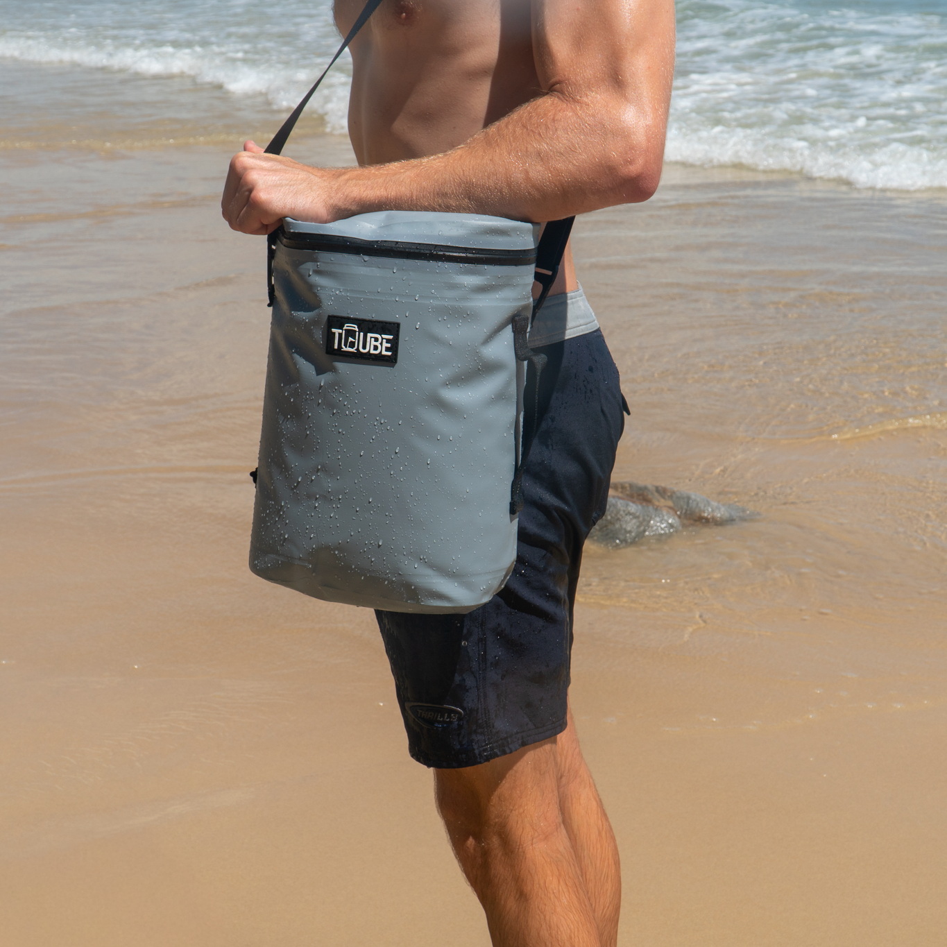 Tuube Weekender 8L grey cooler bag attachment point detail, carried on the beach
