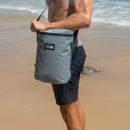 Tuube Weekender 8L grey cooler bag attachment point detail, carried on the beach