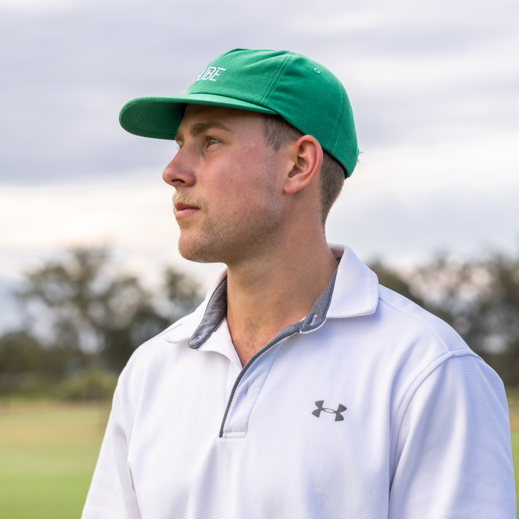 Green Tuube 5-panel hat rear view showing velcro adjustable strap and 5-panel structured crown, 100% cotton golf hat