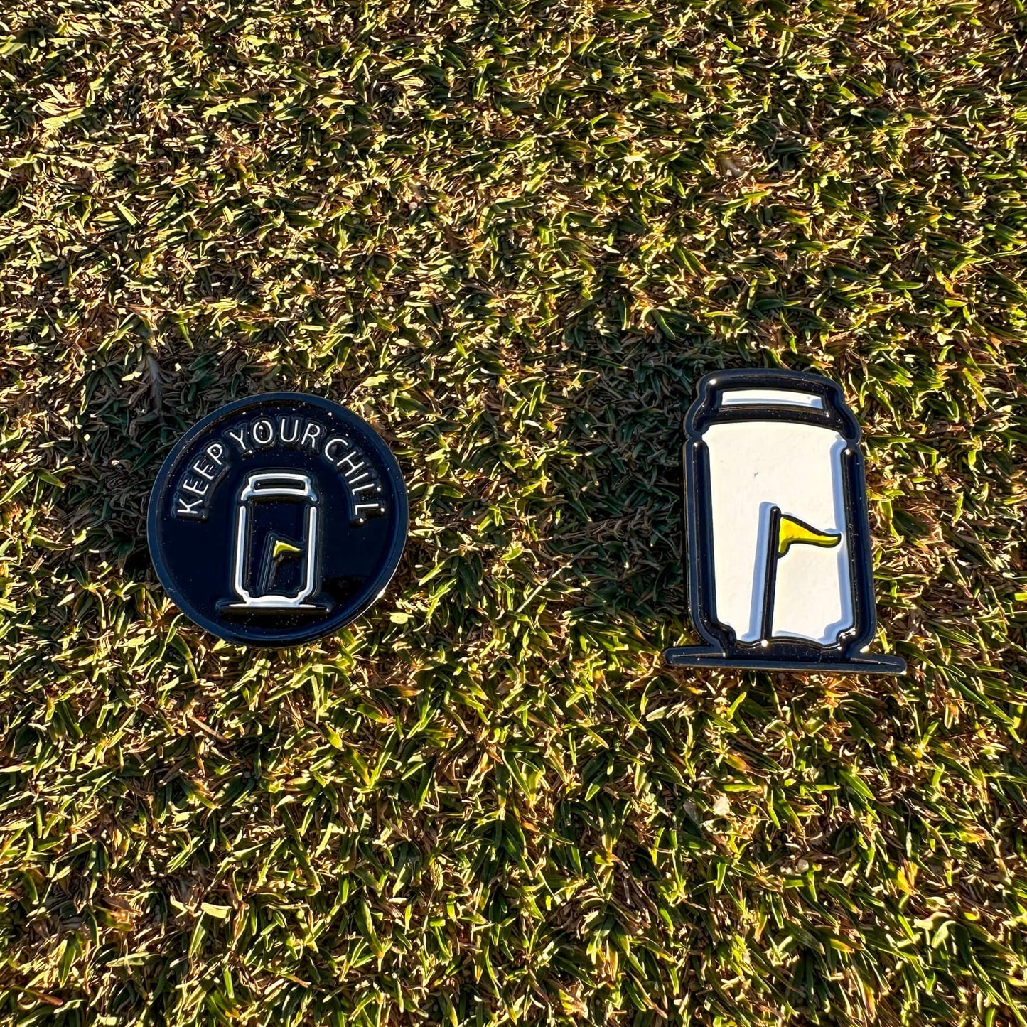 Tuube Keep Your Chill ball marker placed on short cut green grass, close-up showing coated metal finish and easy visibility