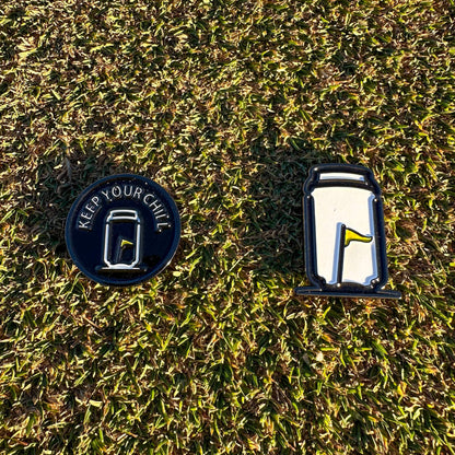 Tuube Keep Your Chill ball marker placed on short cut green grass, close-up showing coated metal finish and easy visibility