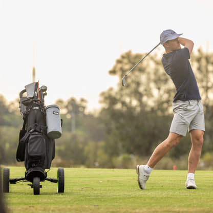 Lifestyle shot of grey Tuube 2.0 golf bag cooler in use on a golf course, demonstrating attachment to a walking golf trolley bag