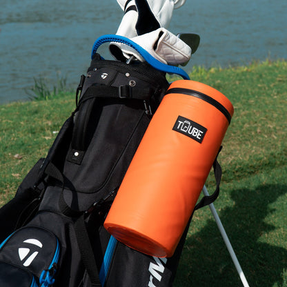 Orange Tuube 2.0 cooler bag clipped to a golf bag with carabiner attachment, vibrant orange PVC exterior on course