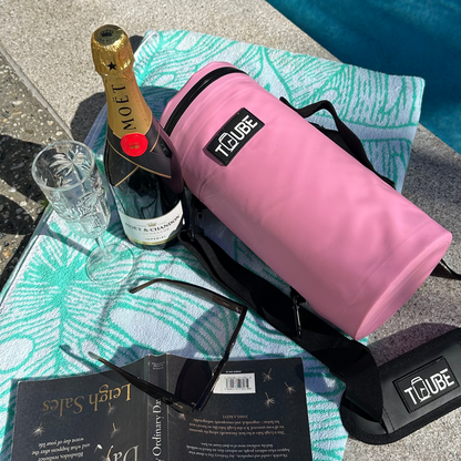 Pink Tuube 2.0 cooler bag attached to a golf bag on the course, showing vibrant pink PVC exterior and carabiner clip