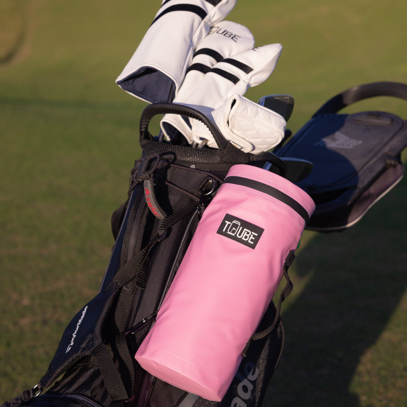 Golfer with pink Tuube Cooler Bag 2.0 clipped to their bag during a round, keeping drinks cold from tee to green