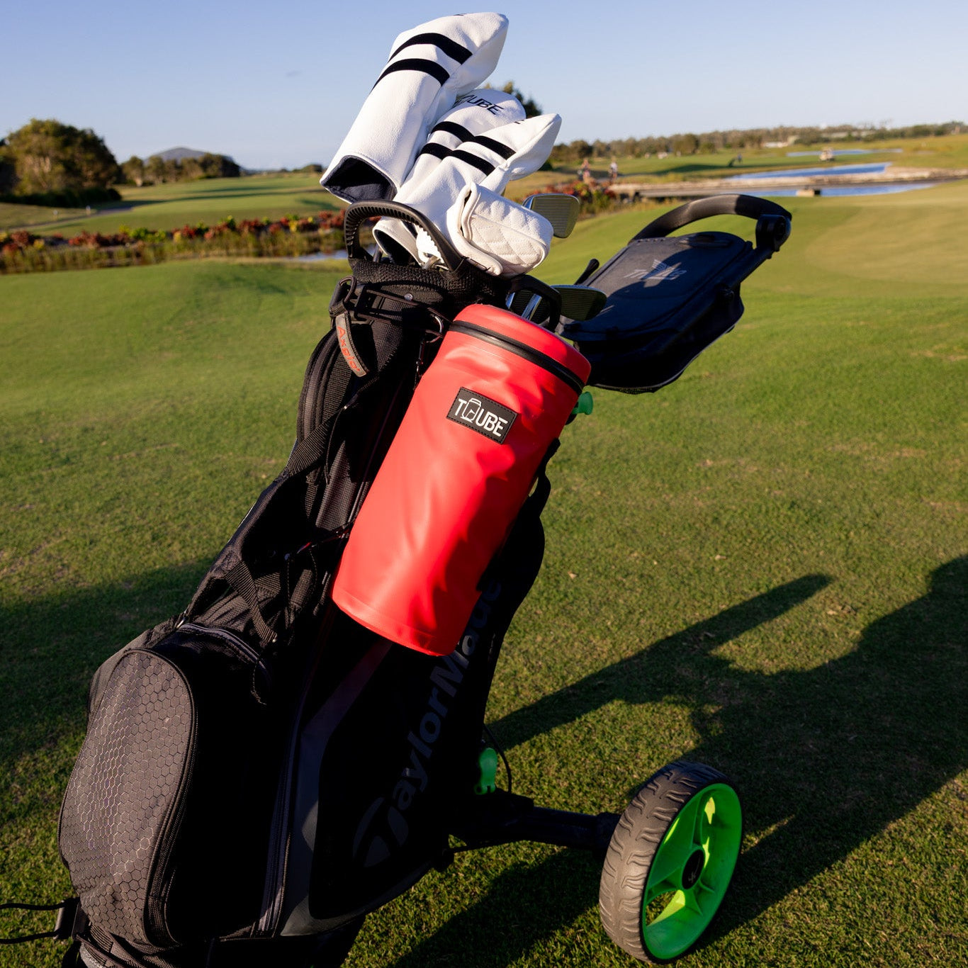 Red Tuube 2.0 cooler bag clipped to golf cart bag, demonstrating versatile looping attachment system on course