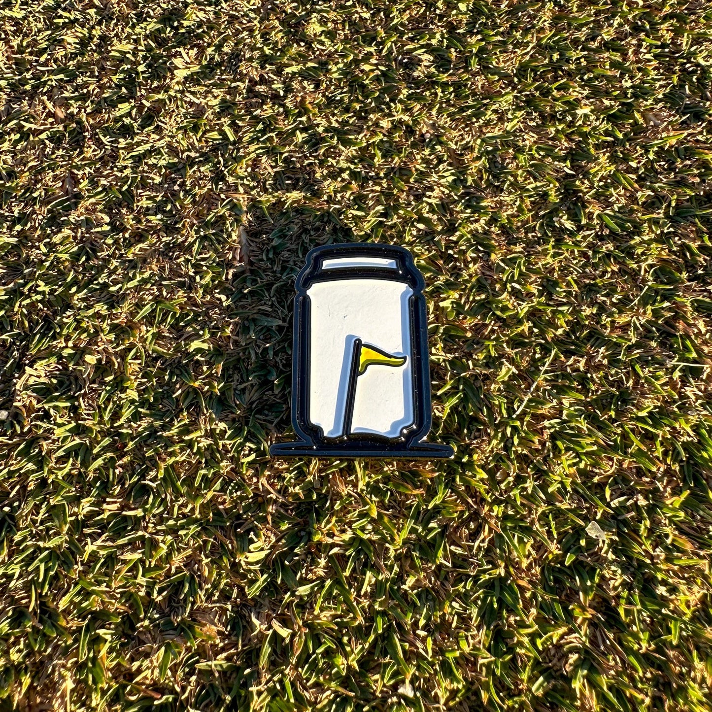 Tuube Can Ball Marker placed on a golf green during a round, showing scale and visibility of the can-design metal marker