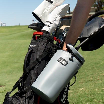 Grey Tuube XL cooler bag open on a golf course showing 8-can capacity with ice, leakproof insulated golf bag attachment