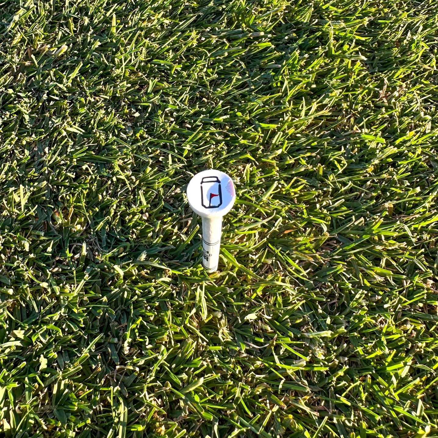Tuube 54mm short golf tees arranged on a course, showing compact profile suitable for iron and fairway wood tee height