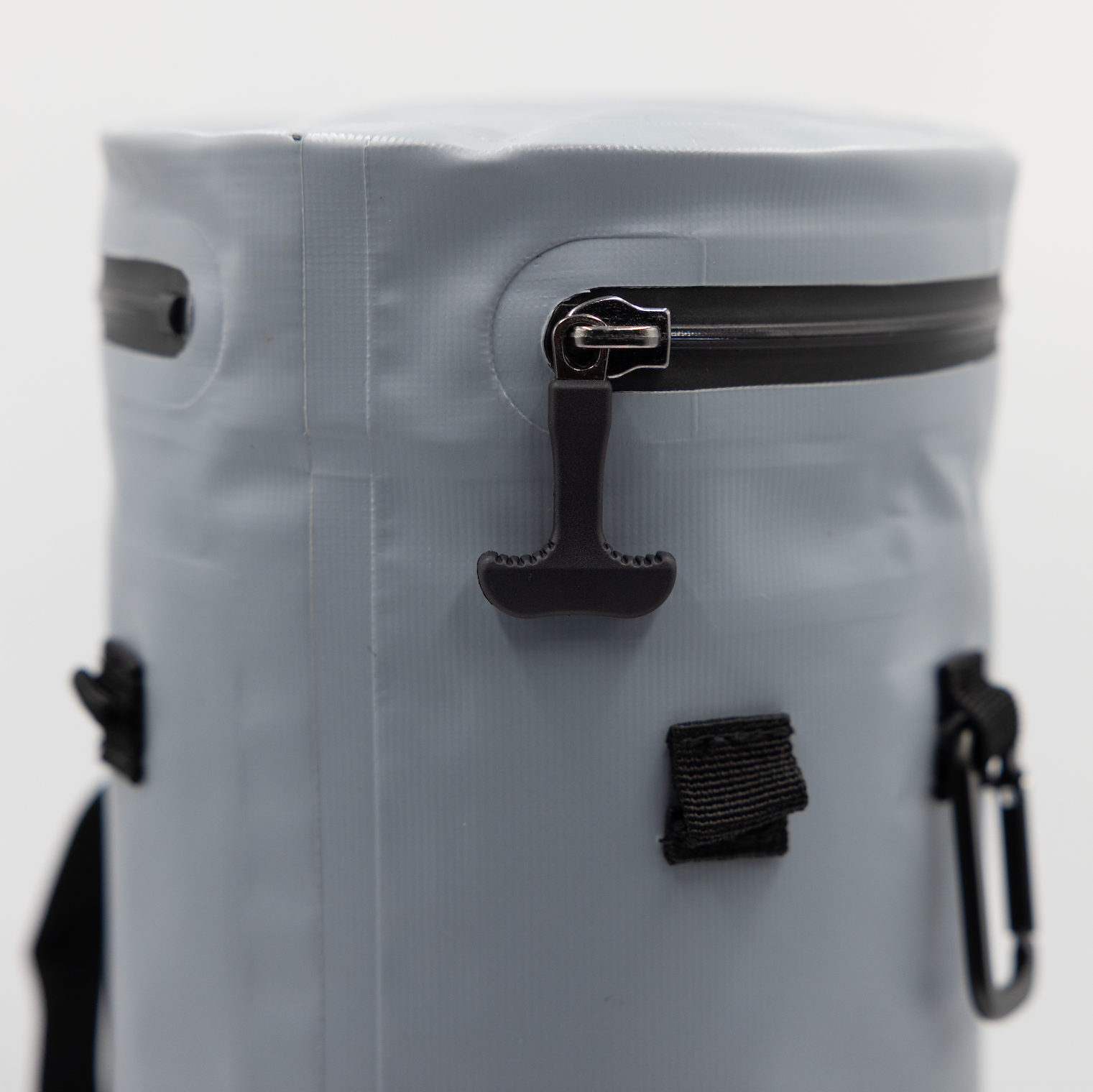 Grey Tuube Cooler Bag 2.0 closeup showing heat-welded seams, carry handle, and leakproof zipper, attachable golf bag cooler